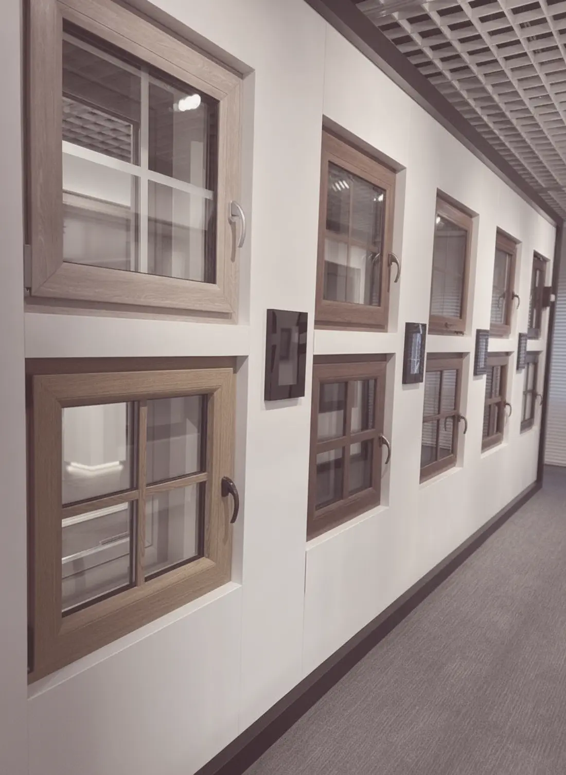 Musterwand mit Fenstern in verschiedenen Holzdekoren im Ausstellungsraum von FensterVision